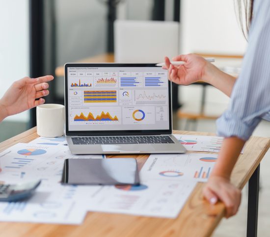 Two members of an inbound strategy team working on data analysis dashboard for business strategy.